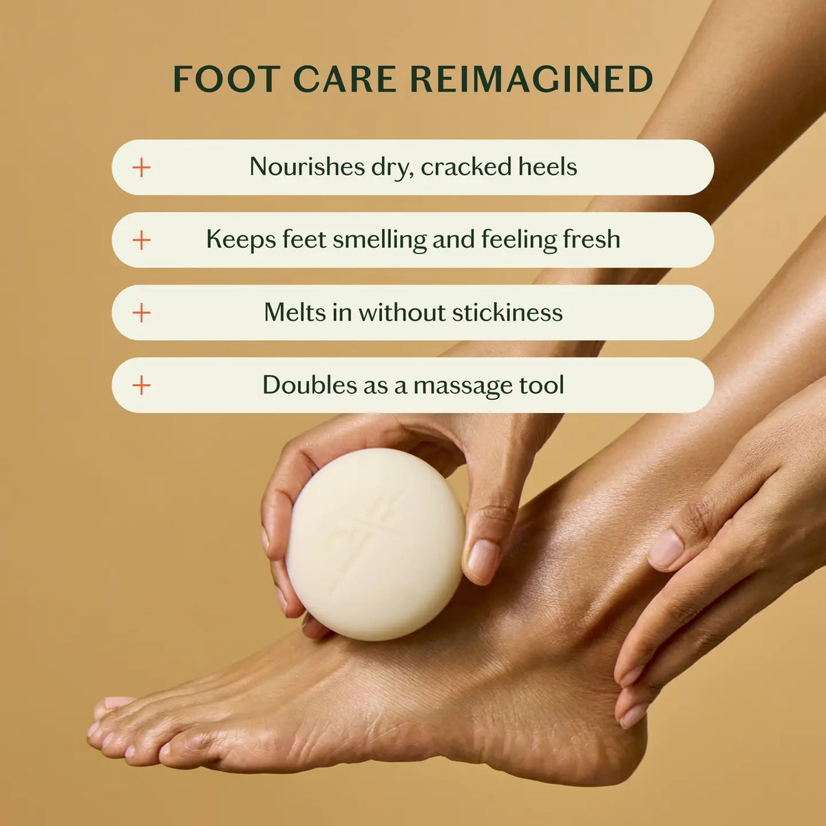 A person uses KATE MCLEOD’s THE FOOT STONE SOLID FOOT MOISTURIZER on their foot, holding the off-white round bar with one hand while the other rests on their ankle. The solid beige background emphasizes care for dry, cracked heels.