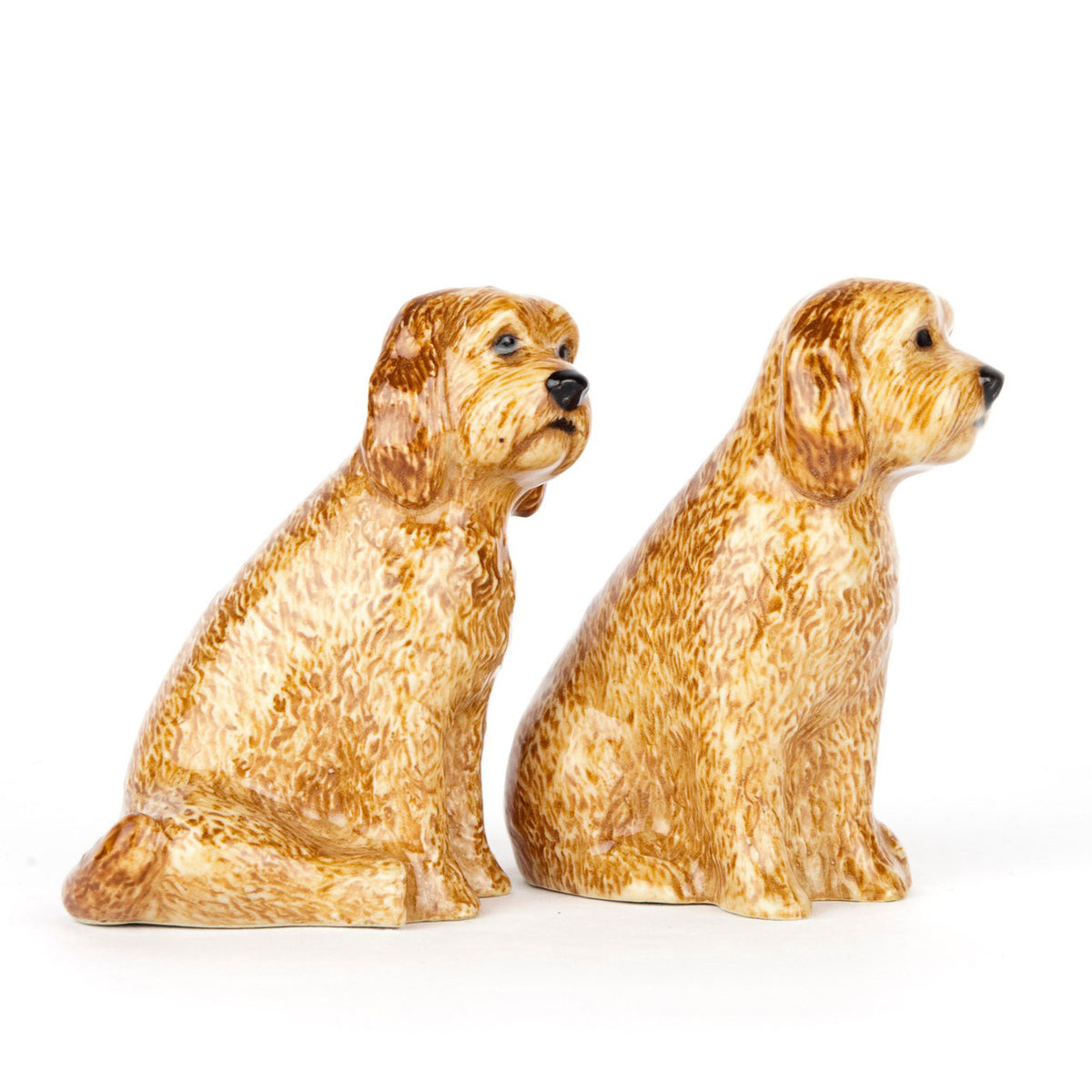 The QUAIL DESIGNS QUAIL CERAMICS - COCKAPOO SALT AND PEPPER SET features two hand-painted, golden-brown dog figurines with textured fur, sitting side by side on a white background, facing slightly forward.