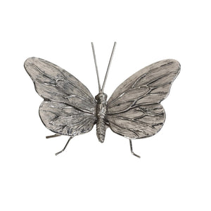 The ZODAX PEWTER BUTTERFLY is a silver metallic sculpture with textured wings, slender antennae, and thin legs. Measuring 4.25 x 3.25 x 1.75 inches, it’s perfect for display in a small box or on a shelf against any backdrop.