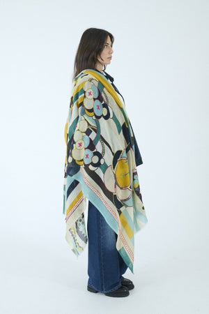 Introducing the STORIATIPIC - BAO Wool Scarf with Embroidery in Blue by STORIATIPIC: a generously sized (100 x 200 cm) wool scarf featuring a modern geometric pattern in teal, mustard yellow, brown, black, and white. Adorned with embroidered circles, dots, and rectangular motifs for a soft texture, this lightweight accessory is finished with frayed edges for added style.