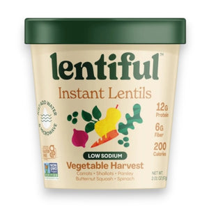 A container of LENTIFUL - LOW SODIUM VEGETABLE HARVEST INSTANT LENTILS by LENTIFUL sits on a yellow background, surrounded by fresh carrot, red onion, garlic, fennel, and squash.