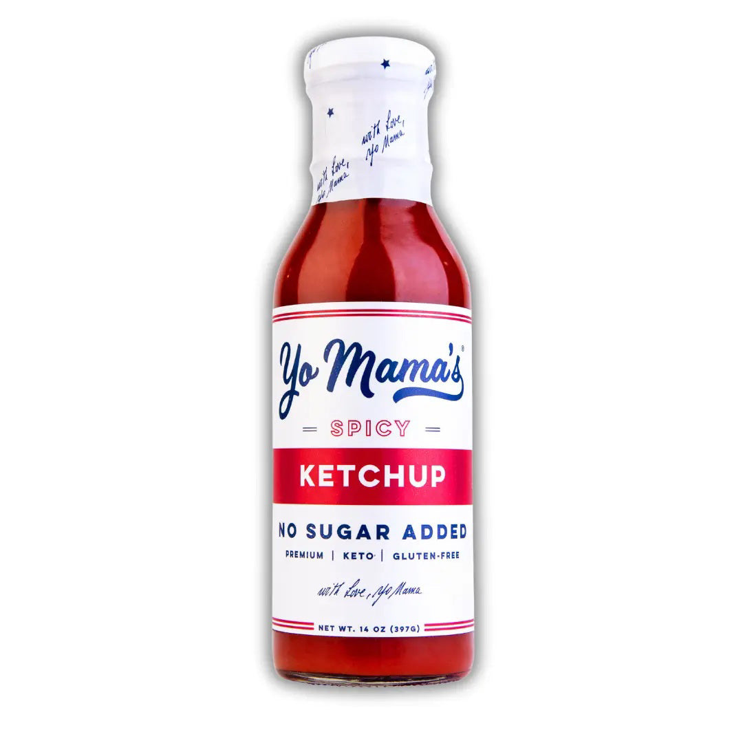 A bottle of YO MAMA'S - SPICY KETCHUP from YO MAMA'S FOODS is shown. The label indicates it is premium, keto, and Paleo-friendly. The net weight is 14 oz (397g). The bottle has a red cap with blue stars and a white background with red and blue text.