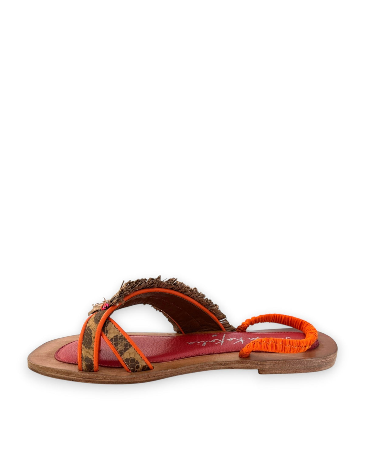 The MEHER KAKALIA - HAMAM SLIDE IN LEOPARD KHAKI sandal by MEHER KAKALIA features a flat toe-ring design with a wooden sole, vibrant red insole, orange heel strap, and brown textured raffia upper straps adorned with decorative accents.