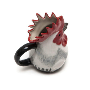 The QUAIL CERAMIC - DORKING ROOSTER JUG by QUAIL DESIGNS is a glazed ceramic mug shaped like a rooster, with a red comb, black beak, and white and black feathers reminiscent of a classic ceramic cockerel jug, displayed against a plain white background.