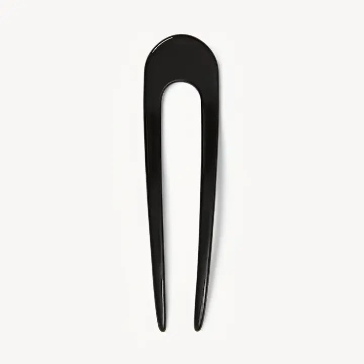 A smooth, black MACHETE - FRENCH HAIR PIN with two prongs, crafted from Italian acetate by MACHETE, rests on a plain white surface.