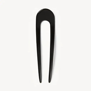 A smooth, black MACHETE - FRENCH HAIR PIN with two prongs, crafted from Italian acetate by MACHETE, rests on a plain white surface.