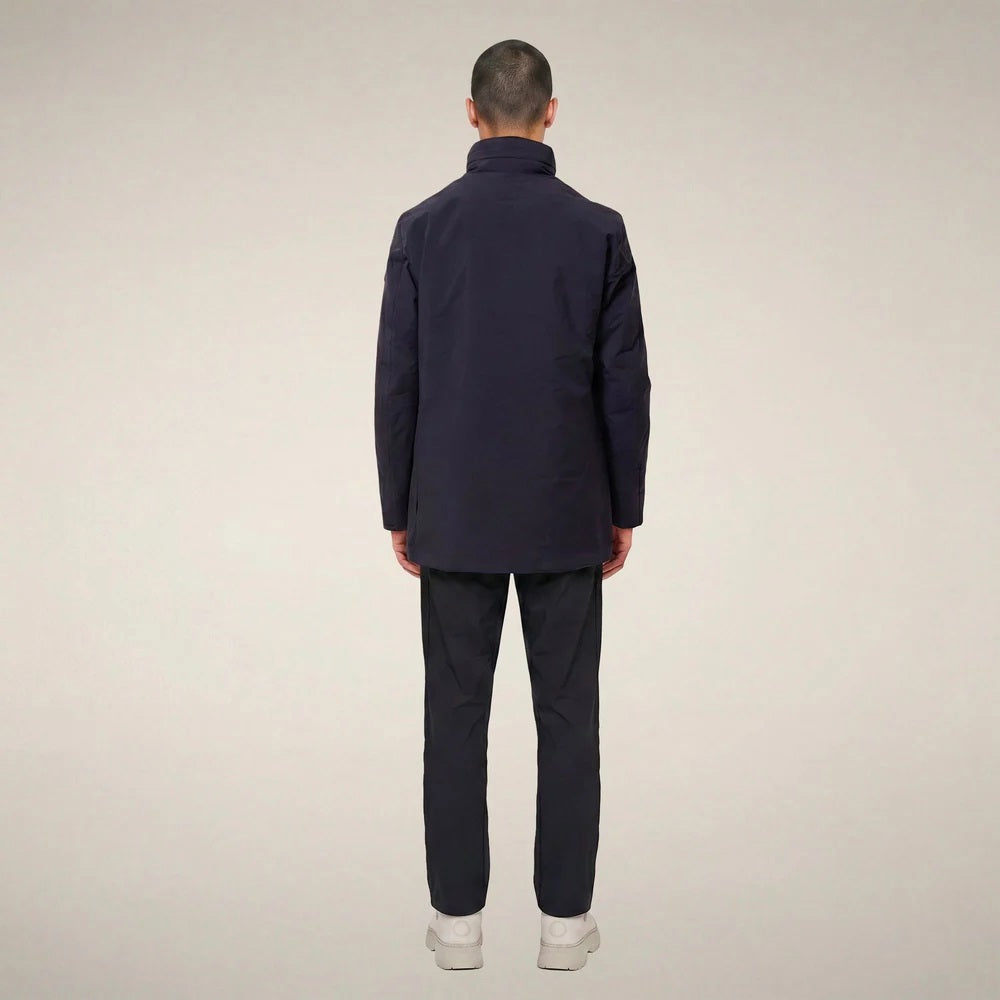 A man wears a dark blue SAVE THE DUCK - BLAISE JACKET IN BLUE BLACK with a high neck and a zippered chest pocket.