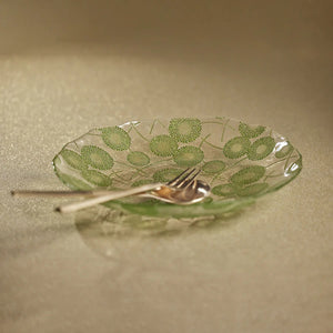 The ZODAX DANDELION LUSTER GLASS SERVING BOWL features a clear glass design adorned with delicate green dandelion-like flowers and slender stems, evenly spread across its surface and shown against a white background.