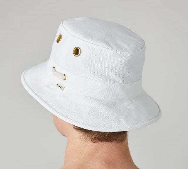A person wearing the TILLEY - ICONIC T1 BUCKET HAT IN WHITE and a white shirt is shown from the back against a light gray background—a stylish, breathable cotton hat by TILLEY, perfect for sun protection.