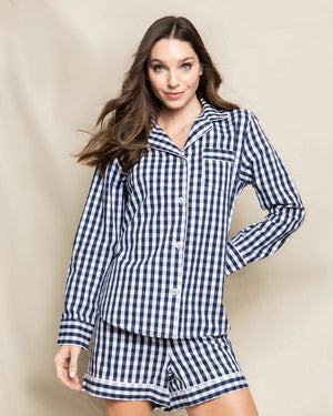 Introducing the FEARRINGTON LIFESTYLE COLLECTION - WOMEN'S TWILL PAJAMA SET IN NAVY FRENCH TICKING by PETITE PLUME. This set features a collared, long-sleeve shirt with a front pocket and button closures, paired with matching pants that have a drawstring waistband. Both pieces are adorned in a classic white and light blue striped pattern.