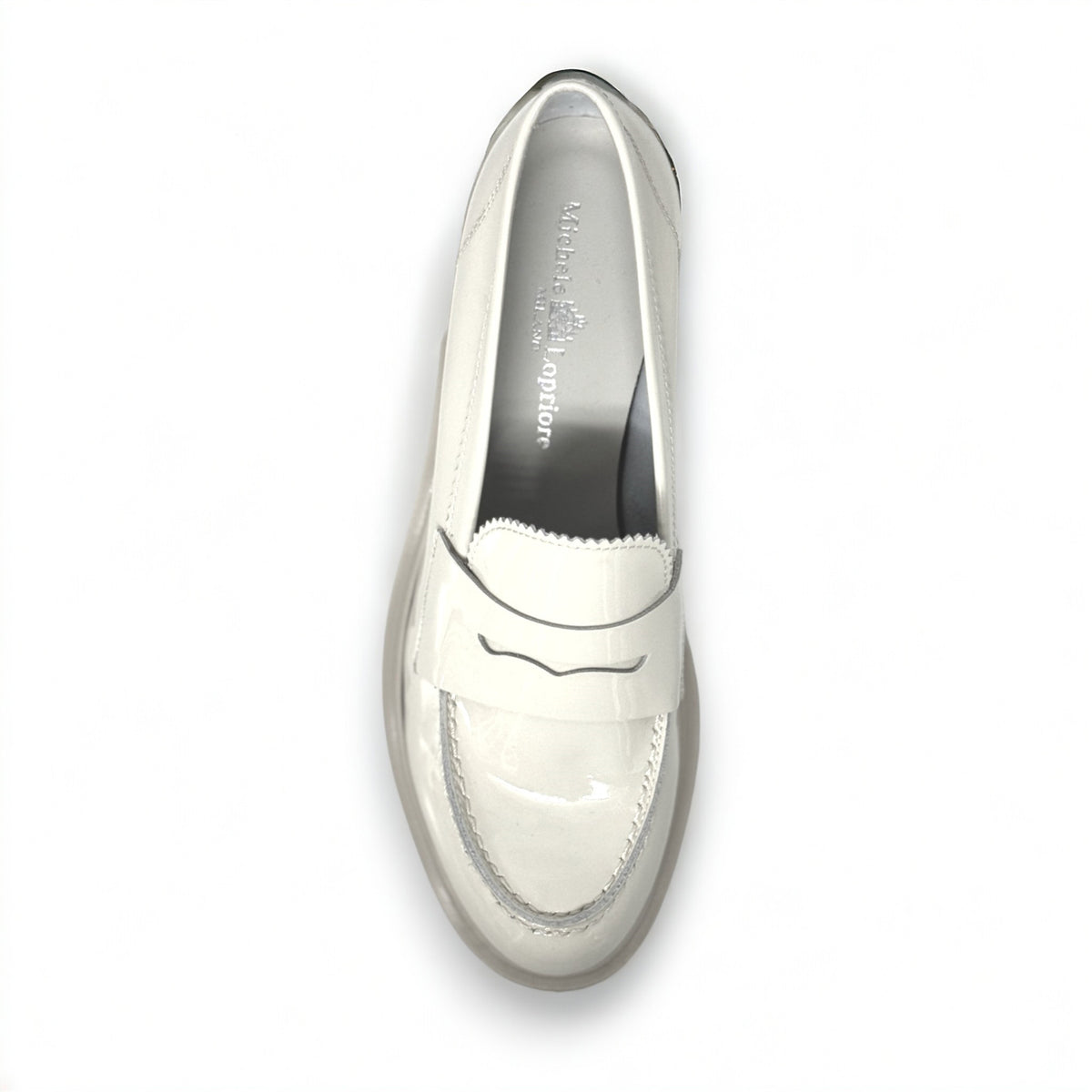 A single ANNA Loafer in Butter by MICHELE LOPRIORE, made with beige patent leather and featuring a chunky rubber sole, is displayed against a white background. This classic shoe showcases subtle stitched details and boasts a 3 cm height for added style.