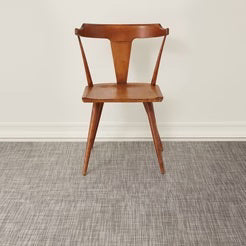 The CHILEWICH - BASKETWEAVE FLOORMAT by CHILEWICH features a subtle gray and white woven pattern in a minimal, neutral rectangular design, made with recycled content for eco-friendly appeal.