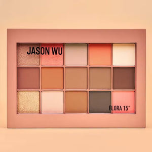 The JASON WU BEAUTY FLORA 15 EYESHADOW is a large, rectangular shadow palette that features 15 vibrant shades. It includes a variety of matte, shimmer, and metallic finishes in tones ranging from neutrals to bold colors like peach and pink. The name 'JASON WU' is printed inside the palette.