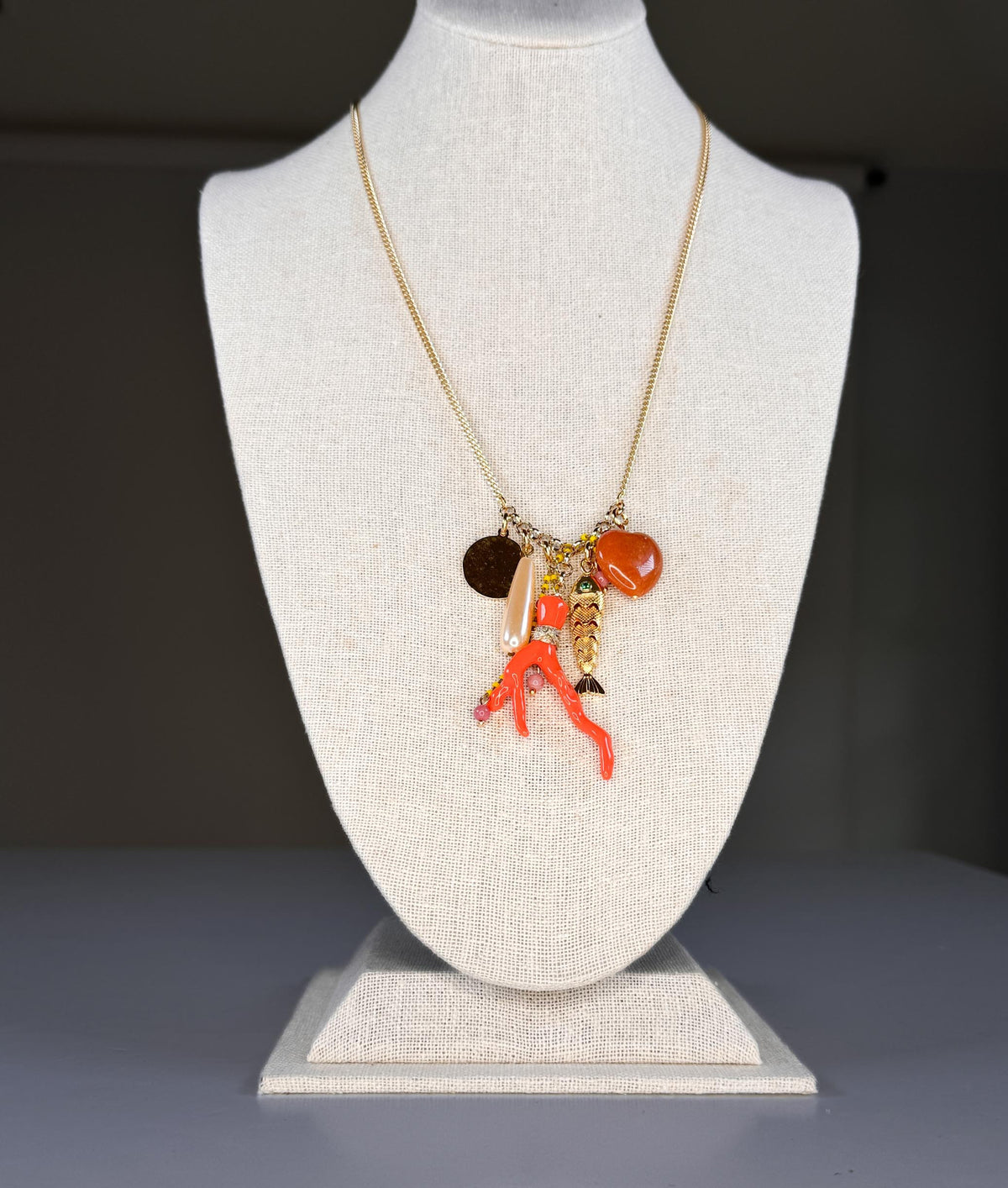 The SANDRINE FRANCE STUDIO SPLASH NECKLACE is a handmade gold chain necklace from NYC, featuring a long cluster pendant with assorted charms—all displayed on a white background.