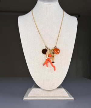 The SANDRINE FRANCE STUDIO SPLASH NECKLACE is a handmade gold chain necklace from NYC, featuring a long cluster pendant with assorted charms—all displayed on a white background.