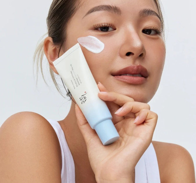 The BEAUTY OF JOSEON RELIEF SUN AQUA FRESH SPF50 by GLOWISS features Korean text with a gradient design transitioning from white to light blue, capped in blue. Experience its lightweight texture for hydrating, non-greasy protection.