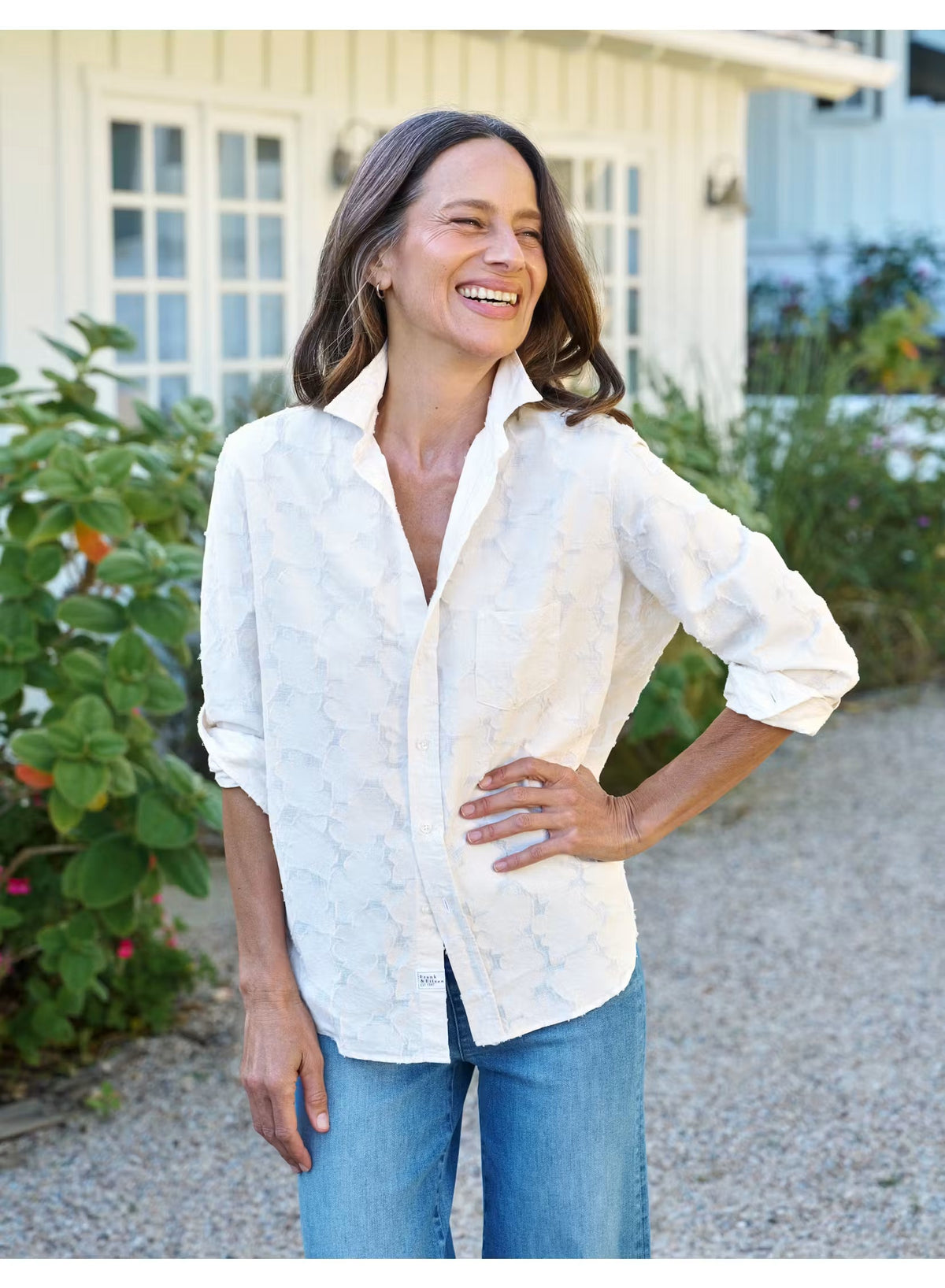 Introducing the FRANK & EILEEN - EILEEN Relaxed Button Up in Italian Cotton Textured Natural Flowers: a long-sleeve, button-up white shirt with a subtle floral texture, rolled cuffs, and a pointed collar. Designed for a relaxed fit, this shirt is crafted from premium Italian cotton and features thoughtfully placed buttons to flatter the bust for an effortlessly stylish silhouette. The signature label inside reads “FRANK & EILEEN EST 1947.”.