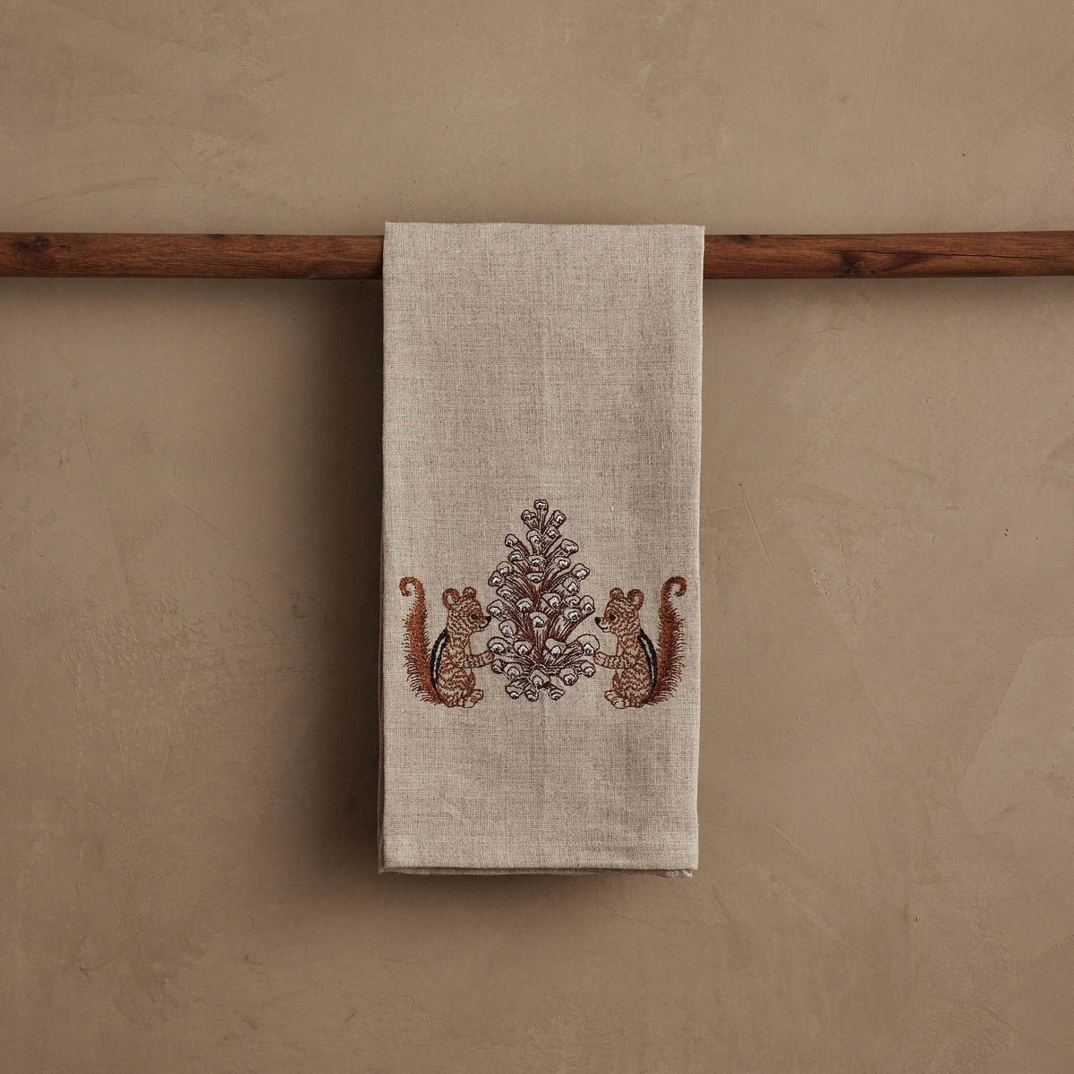 CHIPMUNKS WITH PINECONE LINEN TEA TOWEL by CORAL & TUSK featuring embroidered chipmunks holding a large, stitched pinecone.