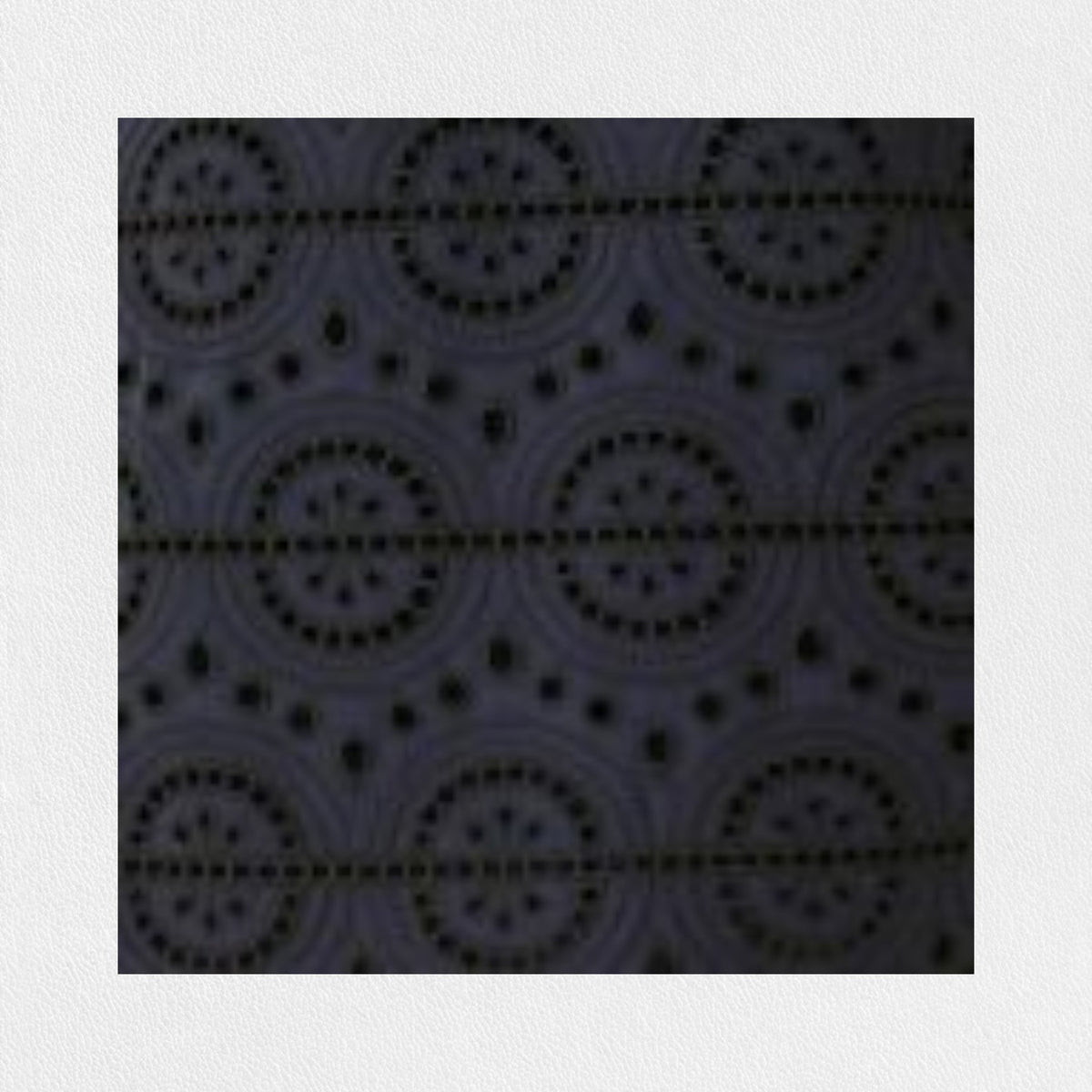 A person stands against a plain background wearing the SFIZIO - BRODERIE ANGLAISE MIDI DRESS by SFIZIO, which features elbow-length puffed sleeves and a midi-length skirt adorned with intricate lace patterns. They are also wearing black ankle-strap sandals.