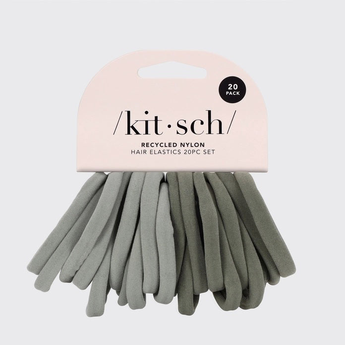 A KITSCH set of 20 eco-friendly nylon elastics in muted green, made from recycled materials. These essential hair ties come packaged under the "KITSCH" brand, displayed on hanging packaging with brand and product details.