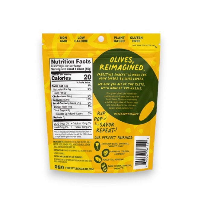 A yellow packet of FREESTYLE - LEMON GARLIC GREEN OLIVES from FREESTYLE SNACKS, featuring green olives flavored with extra virgin olive oil. The packaging highlights the "all-natural" ingredients and notes that the olives are "grown in Greece." Weighing 4 oz (113g), the pack showcases images of green olives alongside phrases such as "pitted &amp; unpasteurized" and "healthy snacking on the go.