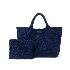 The PARKER & HYDE Oversized Woven Tote Bag is a hand-woven black tote with a matching pouch, both featuring a subtle crisscross pattern. The versatile tote has short handles and a sturdy texture, while the pouch includes a convenient zipper closure.