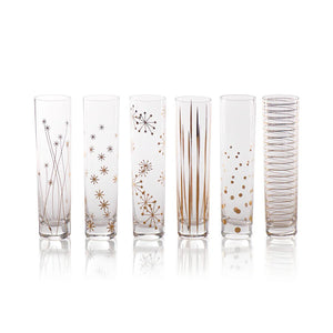 A set of six LA FETE GOLDEN DECAL CHAMPAGNE FLUTES by ZODAX, featuring tall, clear glasses adorned with decorative gold patterns such as stars, lines, and dots, showcased on a reflective surface. For details on dimensions or capacity, feel free to call the store.