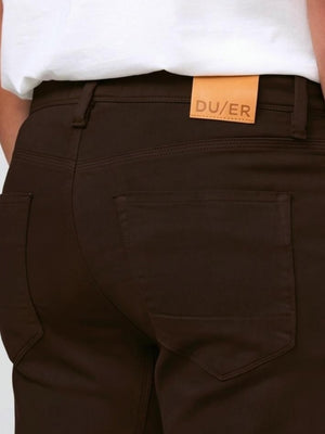 DU/ER - NO SWEAT STRAIGHT PANTS IN STOUT by DUER: Straight-leg, dark brown pants made from No Sweat fabric with front and back pockets, belt loops, and a button closure, shown on a white background.