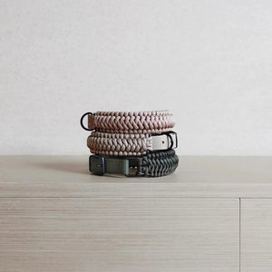 Two LAMBWOLF COLLECTIVE New Jupiter Collars in Moon, size Medium—one in light beige and the other in dark gray—are stacked on a light wooden cabinet against a plain light background. Each collar blends contemporary style with cushioned comfort for your pup.