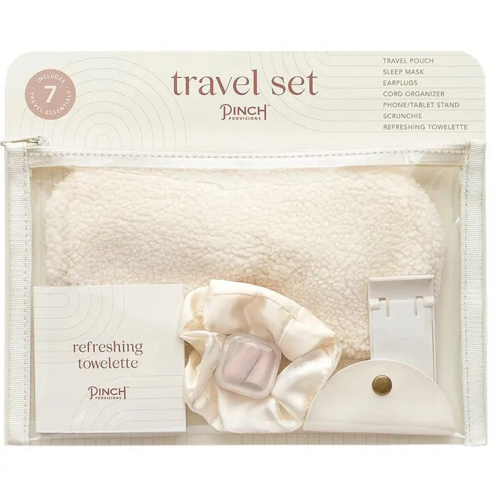 The PINCH PROVISIONS Travel Set is neatly presented in a transparent zippered pouch, designed for the contemporary traveler. Inside, you&#39;ll find a plush sleep mask, earplugs, cord organizer, phone/tablet stand, scrunchie, and a refreshing towelette. The packaging boasts a minimalistic design with &quot;PINCH PROVISIONS - TRAVEL SET&quot; and highlights the included 7 essentials.