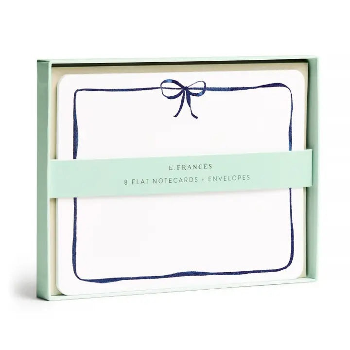 E. FRANCES PAPER's Flat Notes Navy Bow set includes illustrated notecards with matching envelopes, each featuring a blue border and navy bow. Partially boxed with a green band label—ideal for handwritten notes.