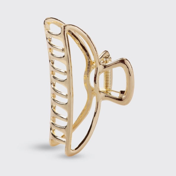 The KITSCH - OPEN SHAPE CLAW CLIP IN GOLD is a minimalist gold metal hair accessory from KITSCH, ideal for styling thick hair and showcased against a plain light background.