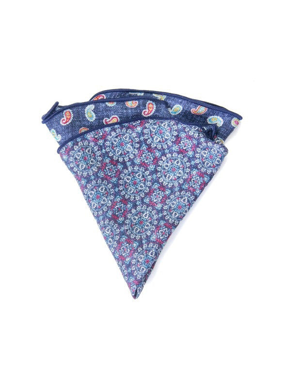The EDWARD ARMAH Silk Reversible Pocket Circle in Denim Paisley features a floral pattern on one side and a vibrant paisley print on the other, folded to highlight both striking designs.