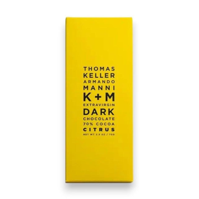 A bright yellow wrapper with centered black text: "K &amp; M EXTRAVIRGIN CHOCOLATE K+M - EXTRAVIRGIN DARK CHOCOLATE CITRUS BAR, Net Wt 2.5 oz / 70g.