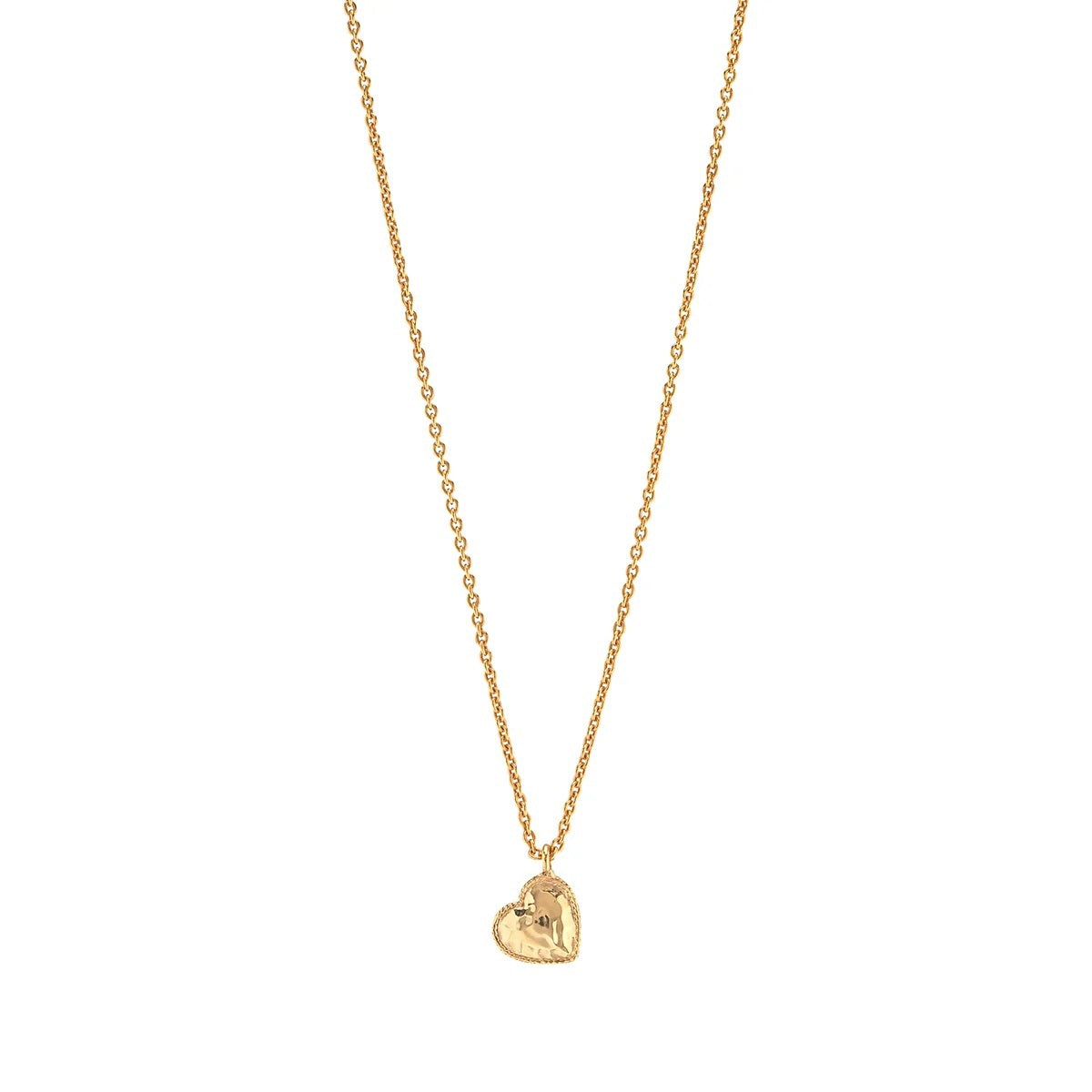The CAPUCINE DE WULF - LOVE HEART CHARM NECKLACE by CAPUCINE DE WULF features a delicate gold chain with a small, heart-shaped pendant engraved with an intricate design, displayed against a plain white background. This elegant handcrafted piece is perfect for adding everyday sophistication to your jewelry collection.
