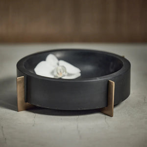 The NAIROBI BLACK MARBLE BOWL by ZODAX features a round, black design with a thick rim and three gold metal legs. Minimalist background accentuates its size: 23.5 cm x 6.35 cm (9.25 in x 2.5 in).