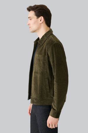 The MACK WELDON - CORDUROY ZIP JACKET is a modern-fit, dark blue corduroy jacket with a front zipper, long sleeves, collar, and chest pocket—shown against a white background.