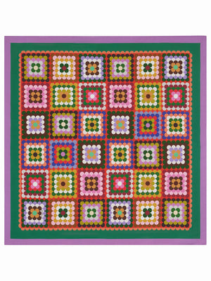 A vibrant quilt showcases geometric squares in pink, red, green, brown, white, and black with green and red borders—each echoing the bold design of the FRANCO FERRARI - CIALDA REVERSIBLE SILK SCARF by FRANCO FERRARI.