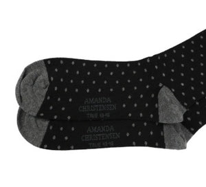 Introducing the AMANDA CHRISTENSEN - TRUE DOT MID-CALF SOCKS IN BLACK: Expertly crafted in Italy, these stylish socks feature a classic black background adorned with small white polka dots. Contrasting gray toes, heels, and cuffs add a distinctive touch, while the premium combed cotton ensures exceptional comfort and timeless elegance.