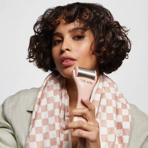 The beige packaging of the "KITSCH - ICE FACE ROLLER," featuring surgical stainless steel, suits sensitive skin. Made from recycled plastic, circular icons on it emphasize benefits like enhanced blood circulation.