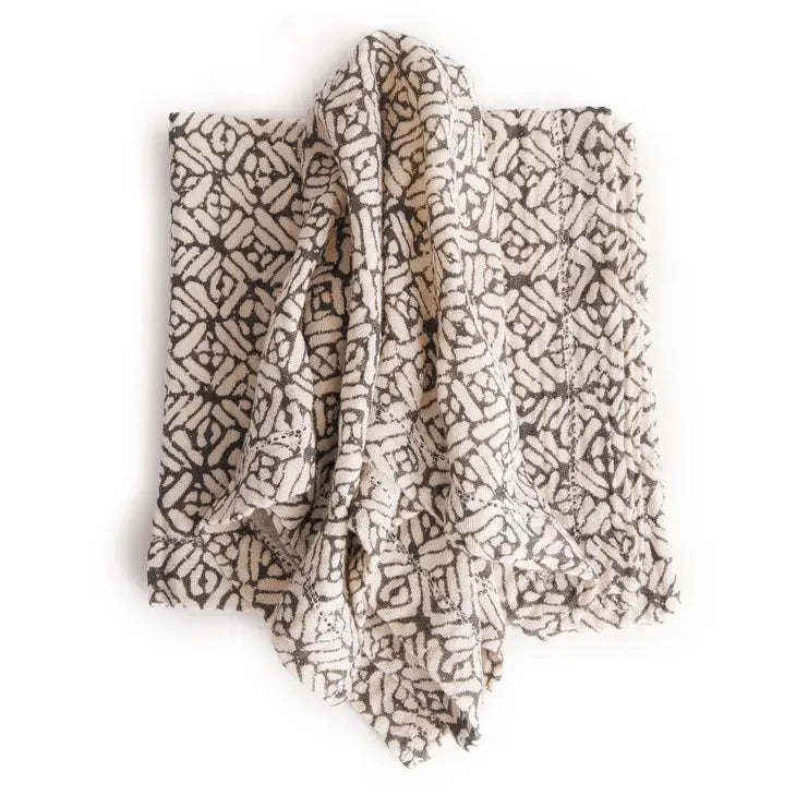 The NAPA HOME AND GARDEN - PIA napkin, crafted from hand-dyed acrylic wool, features a black and white geometric pattern with interlocking shapes for a contemporary and cozy look.