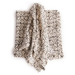 The NAPA HOME AND GARDEN - PIA napkin, crafted from hand-dyed acrylic wool, features a black and white geometric pattern with interlocking shapes for a contemporary and cozy look.