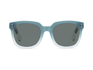 The CADDIS Jockamo Polarized Sunglasses feature a blue-green rectangular design with dark polarized lenses. The premium acetate frame is accented by white-tipped arms, and the brand "Caddis" is prominently displayed on both the lens and arm. These sunglasses combine a vintage aesthetic with a modern, sleek design perfect for casual wear.