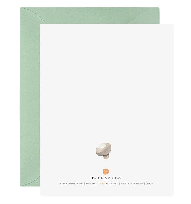 The E. FRANCES - HOLY SHIITAKES card by E. FRANCES PAPER features four watercolor shiitake mushrooms and &quot;HOLY SHIITAKES!&quot; in bold text, paired with a light green envelope. Made in the USA.