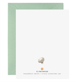 The E. FRANCES - HOLY SHIITAKES card by E. FRANCES PAPER features four watercolor shiitake mushrooms and "HOLY SHIITAKES!" in bold text, paired with a light green envelope. Made in the USA.
