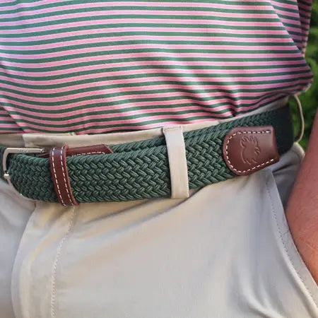 The ROOSTAS SIERRA Woven Stretch Belt features dark green braiding, brown leather accents with white stitching, a silver adjustable clasp, and an embossed rooster logo for a refined touch.