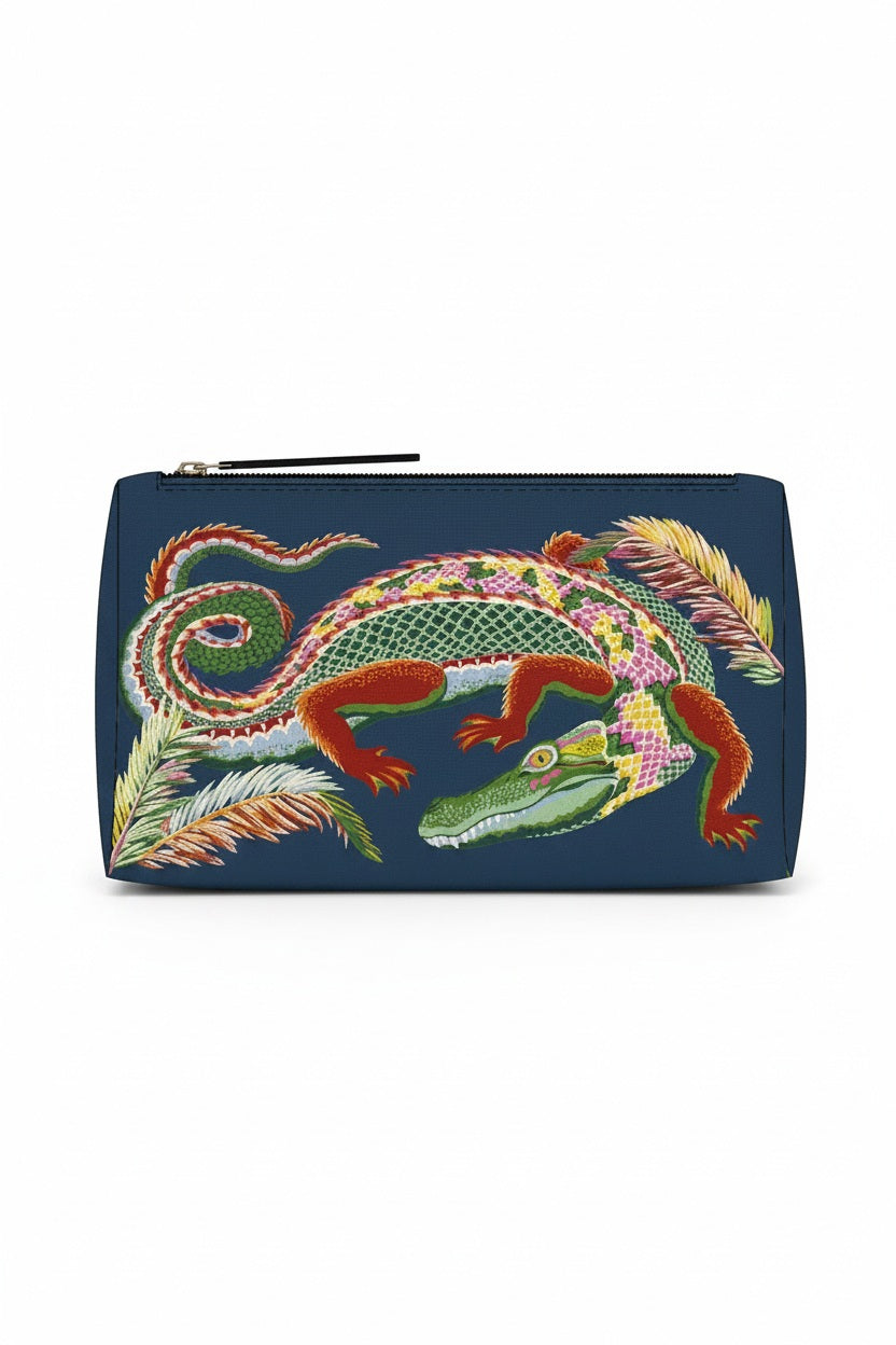 Introducing the INOUI EDITIONS - CROCO COSMETIC POUCH by INOUI, a navy polyester makeup bag adorned with a vibrant embroidered crocodile in green, yellow, and pink patterns, surrounded by multicolored embroidered leaves. Made in India.
