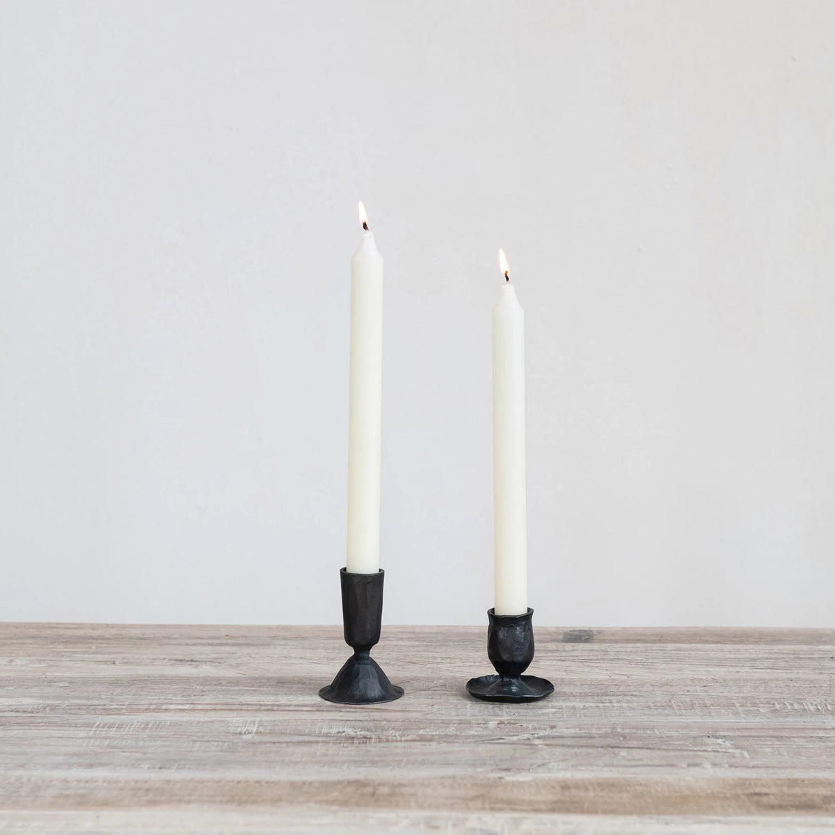 Black, hand-forged CREATIVE COOP HAND FORGED CAST IRON TAPER HOLDER with a hammered finish and a wide, irregular base.