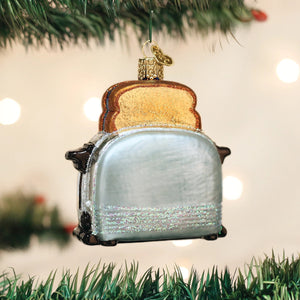 OLD WORLD CHRISTMAS RETRO TOASTER ORNAMENT shaped like a silver pop-up toaster with a golden slice of toast popping out the top.