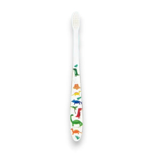 Two HAMICO - KIDS DINO TOOTHBRUSHES by HAMICO/INNOVATIVE TOOTHBRUSH, featuring unique dinosaur designs, sit on a white countertop next to a beige towel. A hint of a green plant is visible in the upper right corner, adding a touch of natural decor to the scene.